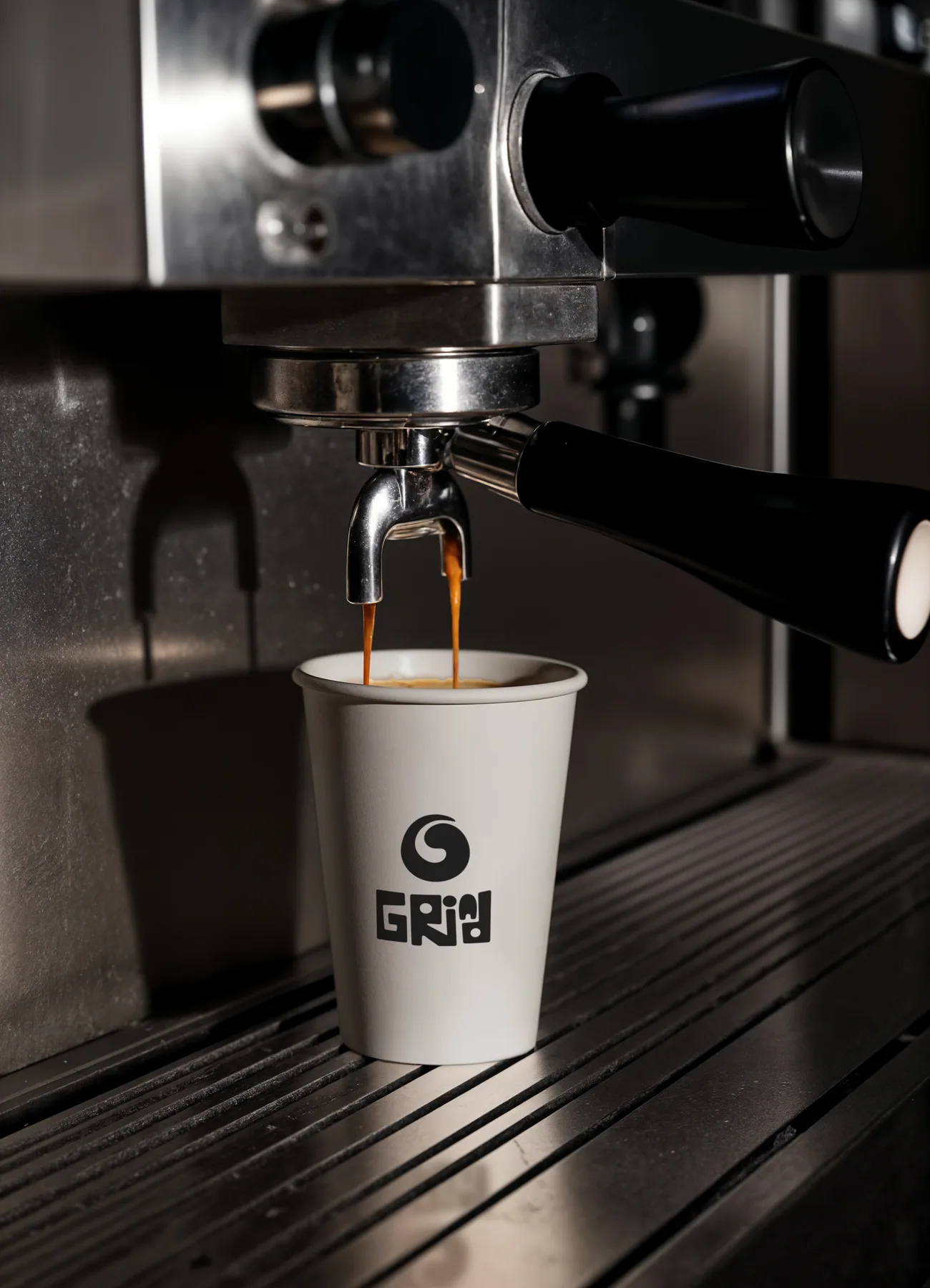 Espresso pouring into a branded Grind cup