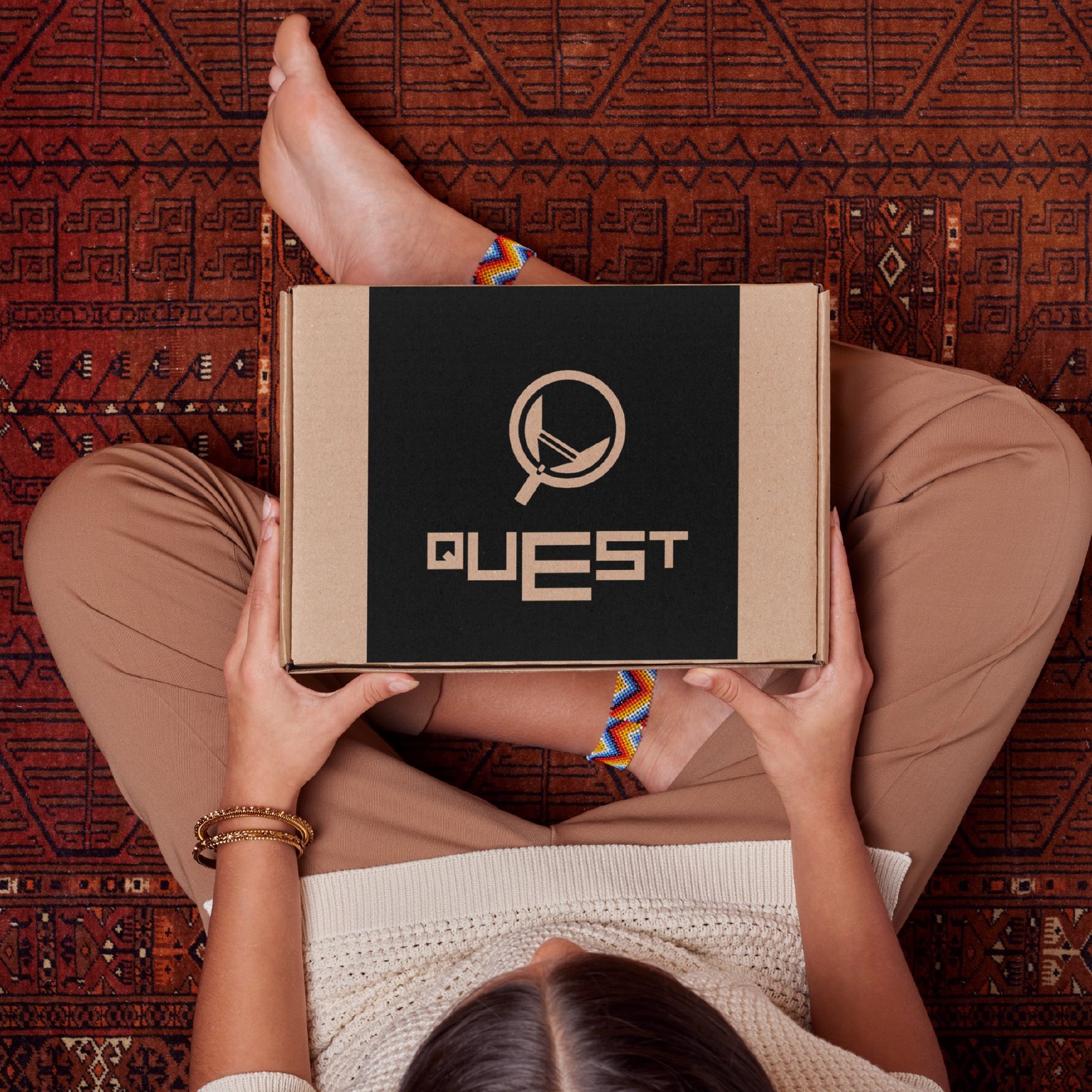 Quest brand packaging — branded box held in hands on patterned rug